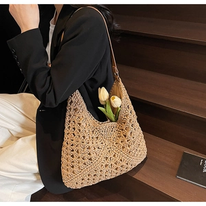 Dettaglio della trama a maglia traforata e tracolla in pelle della borsa hobo