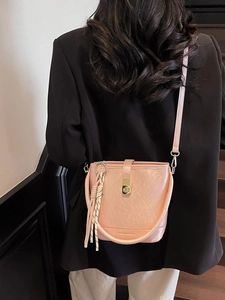 Sac seau rose pour femme en cuir avec fermoir doré et accessoire de pompon à rayures