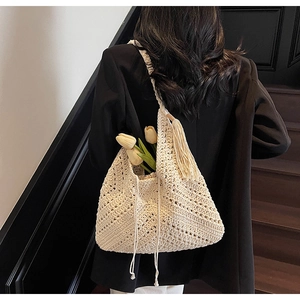 Detail of handmade crochet beach tote with hollow texture and elegant fringe tassel