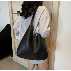 Grand sac hobo noir à texture cuir mat présenté sur un modèle, idéal pour le quotidien