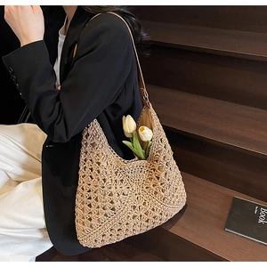 Dettaglio della trama in paglia intrecciata e dell'elegante tracolla in pelle della borsa