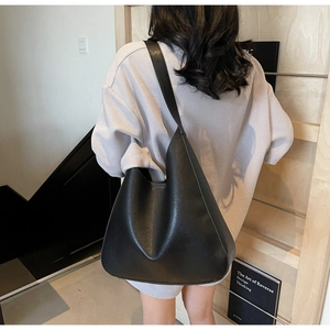 Vue détaillée du grand sac hobo en cuir noir avec une large bandoulière d'épaule