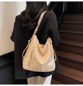 Vista posteriore di una borsa hobo in morbida pelle beige con dettagli a cerniera