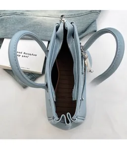 Vista interna della borsa in pelle azzurra con fodera marrone e chiusura a zip metallica