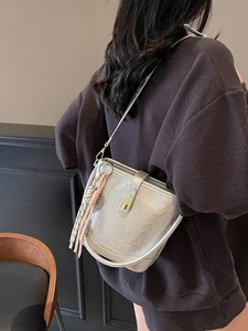 Sac seau argenté métallisé avec fermoir doré et gland rayé sur la bandoulière pour femme