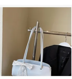 Hellblaue Baguette-Tasche mit weißer Spitzenschleife und schlanken Riemen