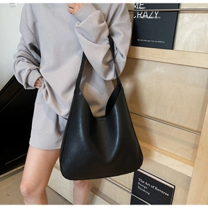 Vue détaillée de la texture et du drapé naturel du sac hobo en cuir souple noir porté