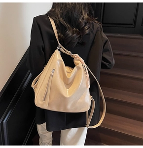 Dettaglio degli spallacci regolabili e texture in pelle PU beige lucida dello zaino
