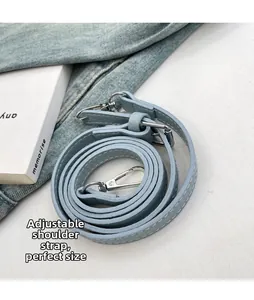 Dettaglio tracolla regolabile in pelle azzurra con moschettoni in metallo argento lucido