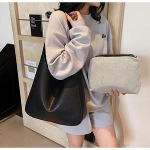 Grand sac fourre-tout noir en cuir et pochette en toile beige avec tenue décontractée