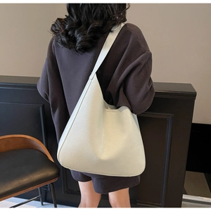 Vue détaillée du sac cabas blanc en cuir grainé avec une bandoulière large et minimaliste