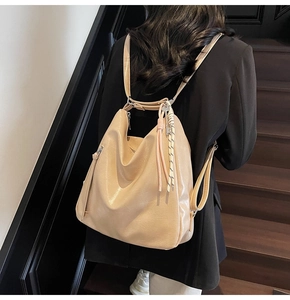 Zaino hobo beige oversize con ciondolo intrecciato indossato da una modella