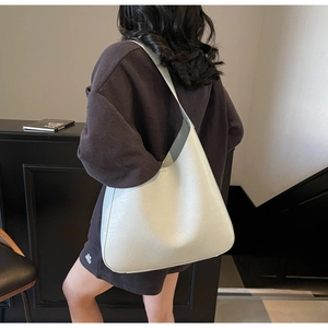 Détail du sac hobo minimaliste crème avec texture en cuir et bandoulière intégrée