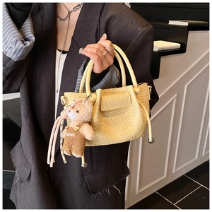 Détail du sac seau jaune clair avec gaufrage crocodile et charmant ours en peluche