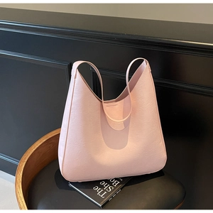 Gros plan sur le sac bandoulière rose en similicuir texturé au design minimaliste