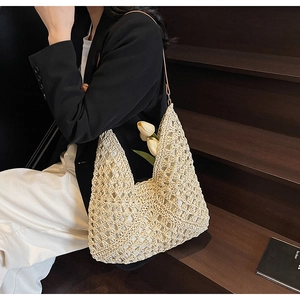 Dettaglio borsa a tracolla beige all'uncinetto con trama a rete traforata e decoro a tulipano