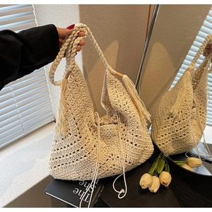 Close-up of handmade crochet shoulder bag with tassel details and drawstring lining