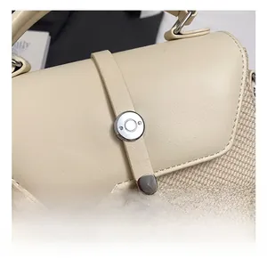 Détail de la texture en cuir beige et tissé avec des rivets en métal argenté poli