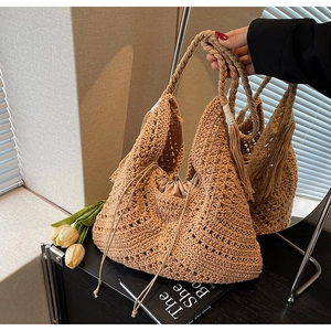 Detail of handmade crochet beach bag with decorative tassels and drawstring liner