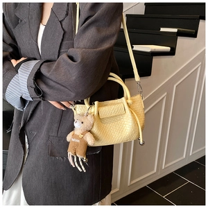 Détails du mini sac seau beige avec motif crocodile et pendentif ours
