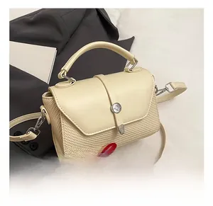 Détail du sac bandoulière crème avec mélange de textures tissées et boucle en métal