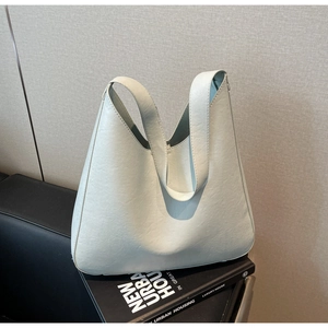 Gros plan du sac fourre-tout vert clair avec texture cuir et poignée intégrée
