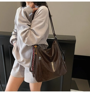 Borsa hobo in pelle testa di moro con nappe e ciondolo a chiave indossata da modella