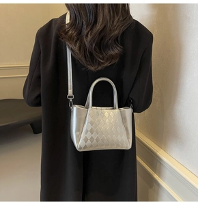 Detail of silver metallic bucket bag with quilted texture and sleek round handle
