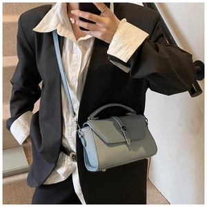 Détail du sac à bandoulière bleu clair avec texture tissée et boucle métallique