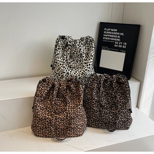 Détail de trois sacs en toile à imprimé léopard avec cordons de serrage variés