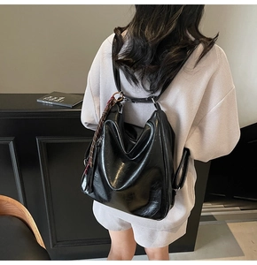Vista posteriore di uno zaino chic in pelle cerata nera con frange indossato da modella