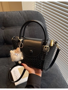 Schwarze Handtasche mit Webstruktur, süßem Monster-Anhänger und verstellbarem Schultergurt