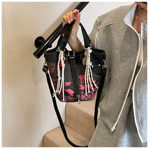 Detail of graffiti bucket bag with pink art patterns and long adjustable shoulder strap