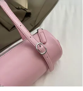 Close-up of pink cylindrical leather bag with polished silver-tone hardware accents