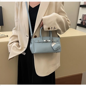 Dettaglio mini borsa Boston in pelle azzurra con ciondolo a cuore e chiusura
