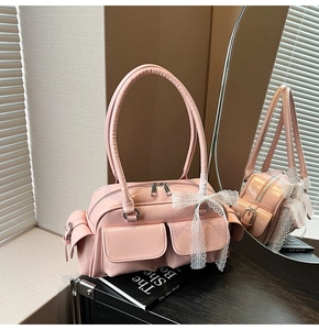 Detailed macro view of glossy pink patent leather Boston bag with white lace bow detail