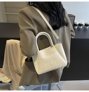 Detailansicht der weißen gesteppten Eimertasche aus PU-Leder mit Tragegriff und Golddekor