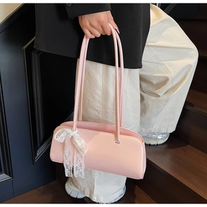 Pink shoulder bag detail with elegant white lace bow charm and smooth leather finish