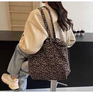 Détail d'un grand sac cabas avec motif léopard porté à l'épaule pour un look élégant