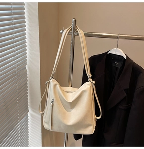 Dettaglio della borsa tote color crema con spallacci regolabili e tasche con zip