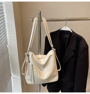 Borsa tote beige in morbida pelle su appendino in metallo con nappe decorative e tracolle