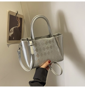 Detail of silver quilted handbag with metallic finish and detachable shoulder strap