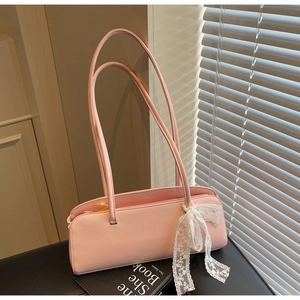Detailed view of pink leather baguette bag with elegant white lace bow decoration
