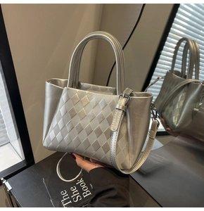 Detail of silver quilted bucket bag with double handles and metallic finish texture