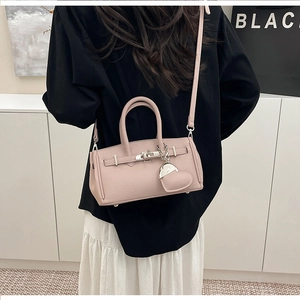 Dettaglio borsa rosa in pelle litchi con chiusura argento e ciondolo a cuore