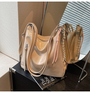 Dettaglio della borsa tote in pelle beige con tracolla intrecciata e zip laterale