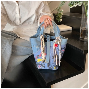 Detail of street-style graffiti denim bucket bag with colorful hand-painted patterns