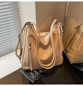 Dettaglio della borsa hobo beige in ecopelle con nappe decorative e cerniere laterali