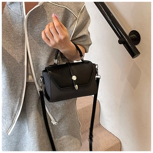 Détail du sac à main noir en cuir et tissage avec boucle métallique et poignée