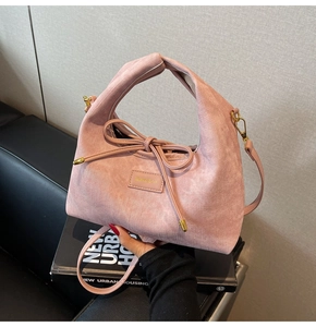 Detailed shot of pink corduroy handbag with knotted handle and bamboo logo